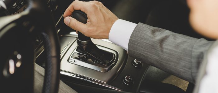 elevated-view-businessman-driving-car-moving-transmission-shift-gear-scaled